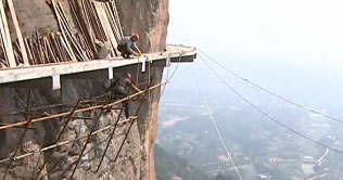 China: Workers building plank roads along cliffs