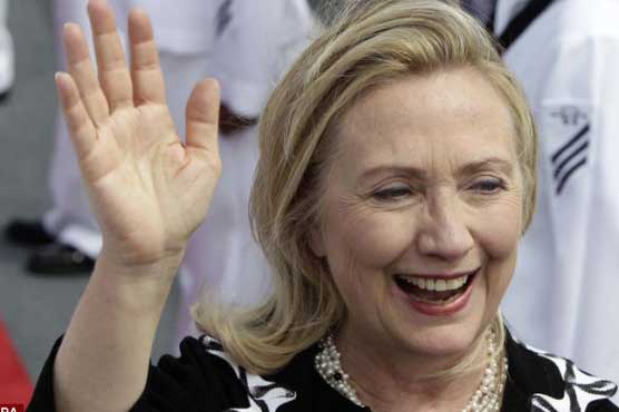 Clinton bursts into laughter as torch bearer runs behind her