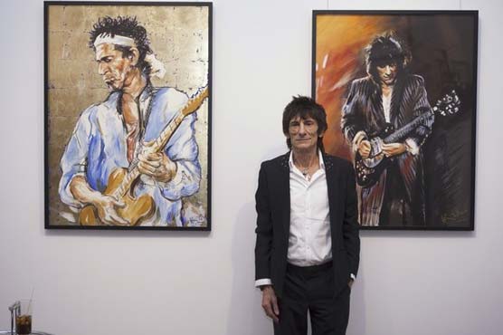 Rolling Stones guitarist Ronnie Wood puts brush to canvas