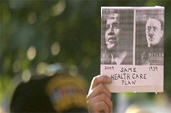 Woman held for removing Obama-Hitler sign 