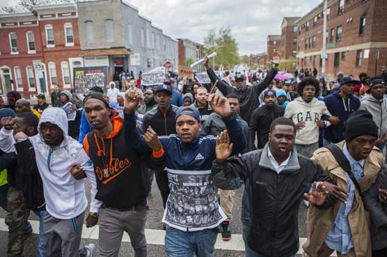 Baltimore protesters defy curfew after police officers
