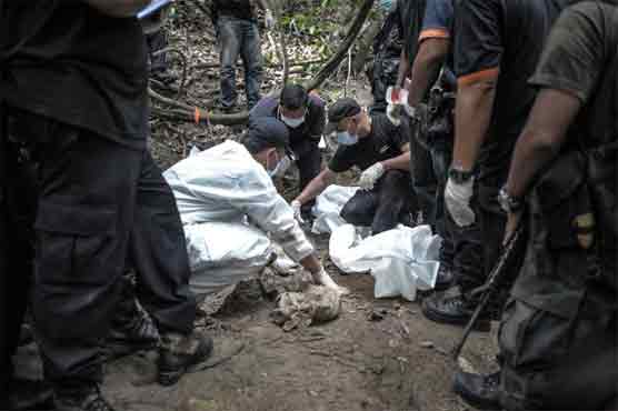 Malaysia says believes 139 bodies in migrant graves