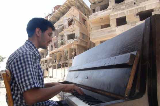 His piano burned by IS, Syrian musician joins migrant tide 