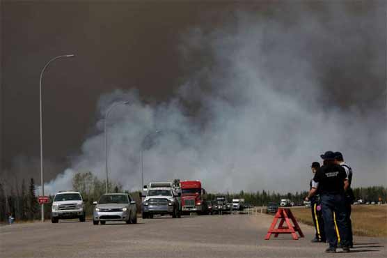 Canadians drive through burning city seeking safety