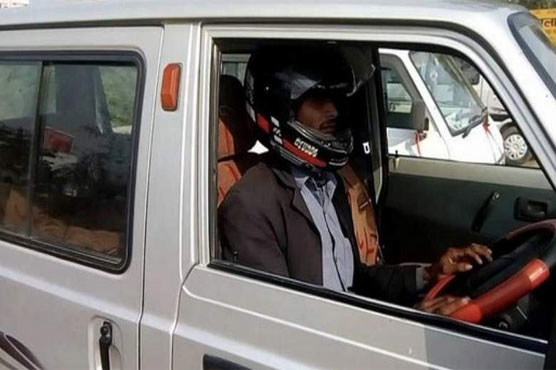 Indian traffic warden fines car driver for not wearing helmet