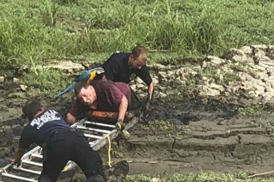 Man rescued from mud with parrot perched on his shoulders