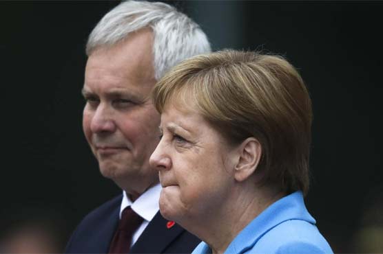Merkel sits through anthems after shaking spells