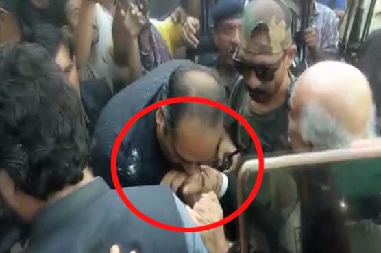 Police officer kisses Khurshid Shah's hand on court appearance 