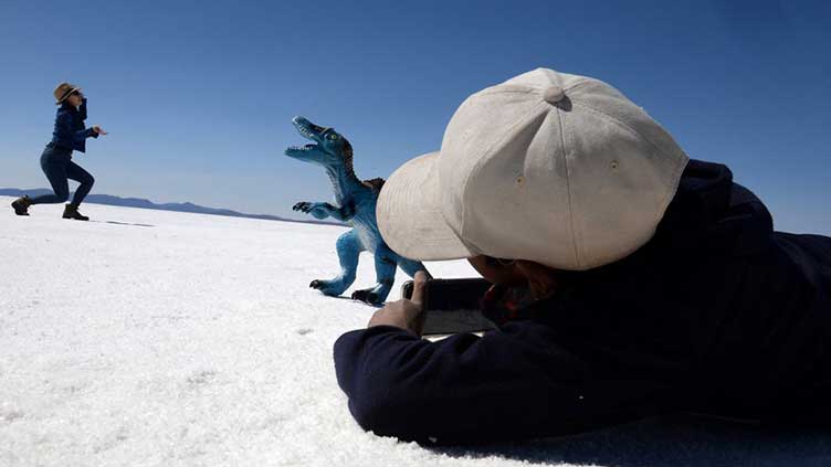 Bolivian boy turns photographer on iconic salt flats - with help from a dinosaur