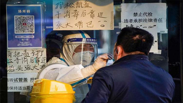 Queues form at fever clinics as China wrestles with COVID surge