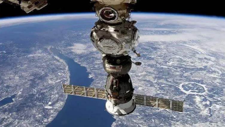 Space crew using robotic arm to inspect damaged capsule