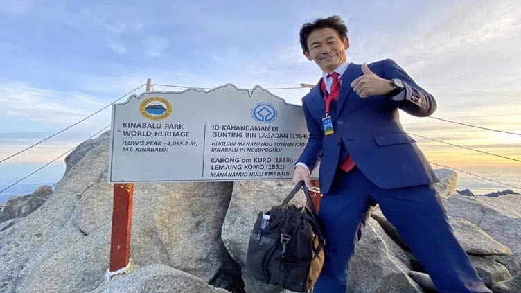 Man climbs 4,100m mountain in three-piece suit and leather shoes