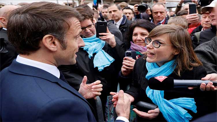Angry crowd heckles France's Macron over pensions legislation