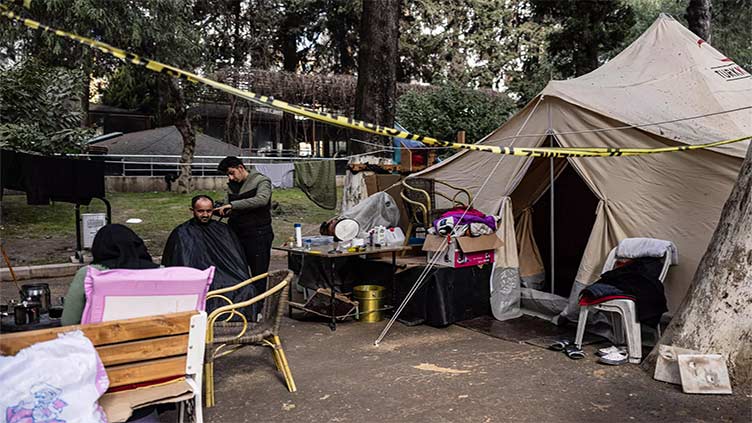 Barber tidies up in Turkiye quake tent camp