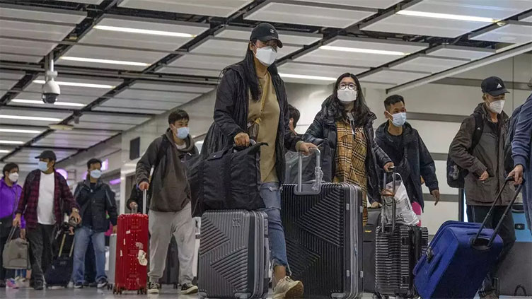 WHO urges travellers to wear masks as new COVID variant spreads