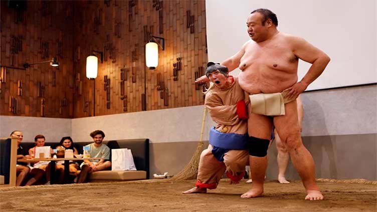 Sumo retirees play for laughs from tourists flooding back to Japan