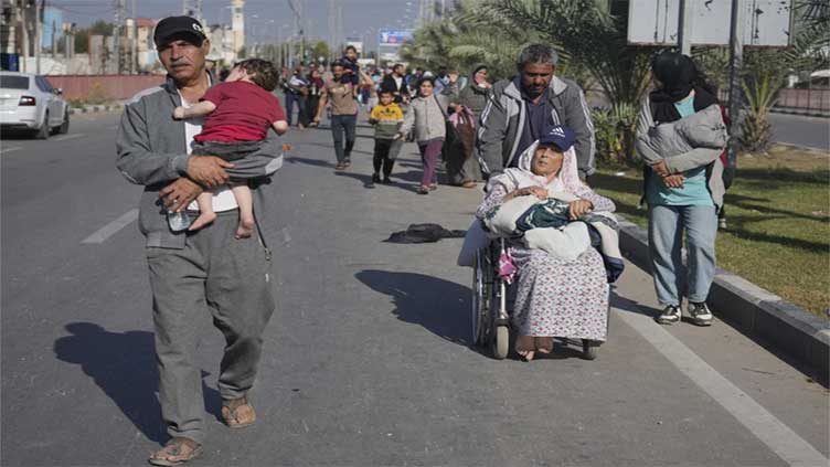 Growing numbers of Palestinians flee on foot as Israel says its troops are battling inside Gaza City