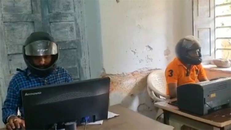 Workers wear helmets in govt offices in India as protection from falling debris