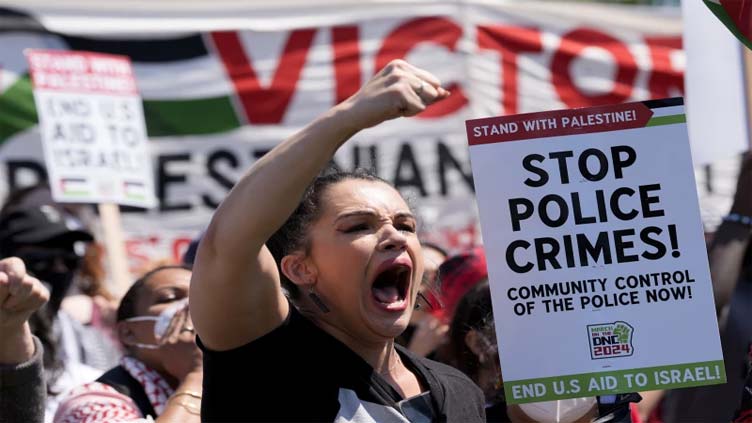 Some protesters tear down security fence as thousands march outside Democratic National Convention