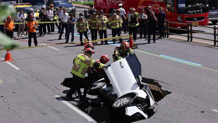 Elderly couple injured after their car falls into sinkhole