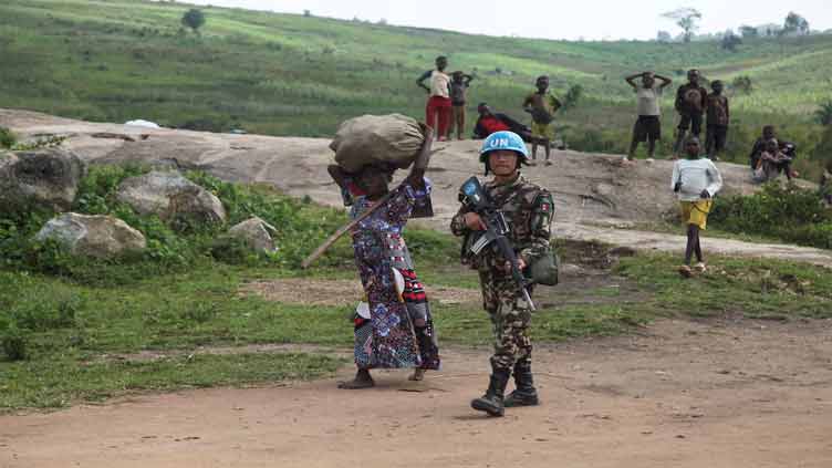 UN peacekeepers guard Congolese farmers working their fields