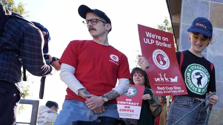 Starbucks workers begin strikes that could spread to hundreds of US stores by Christmas Eve