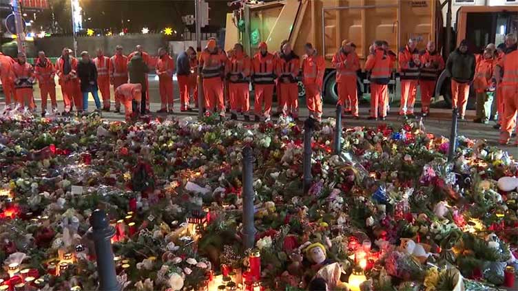 People lay flowers outside church for victims of Christmas market attack