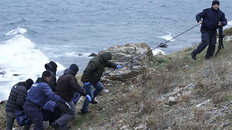 A dinghy carrying migrants hit rocks in Greece, killing 2 people in high winds