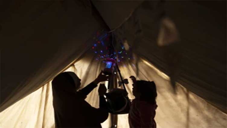 A Gaza family uprooted by war and grieving their losses shares a somber Ramadan meal in a tent