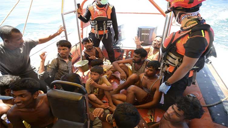 Weeping, weak and soaked, dozens of Rohingya refugees rescued after night on hull of capsized boat