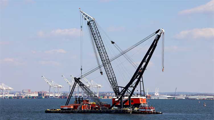 Salvage crews work to lift first piece of collapsed Baltimore bridge