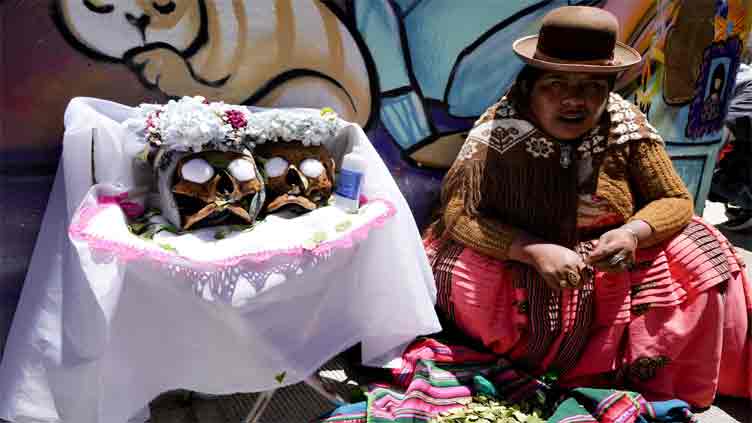 Bolivians carry decorated human skulls asking for favours in their festival