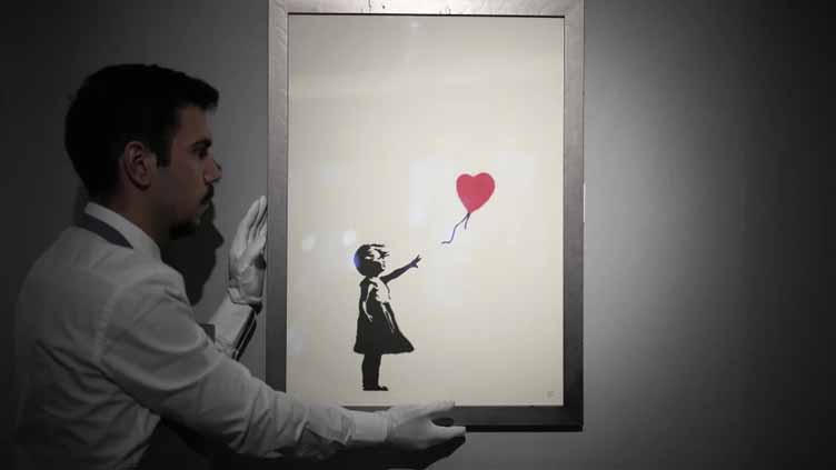 2 men charged with stealing a famous Banksy image from a London art gallery