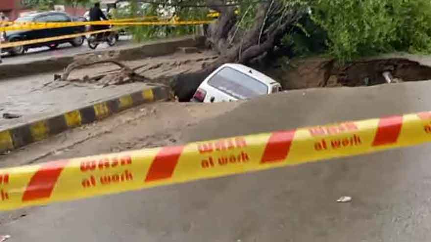 Car plunges into pit after sewer line burst cracks Lahore road