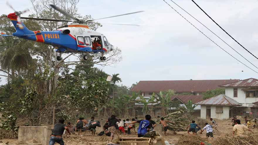 Indonesians climb over logs in walk to aid centre as flood deaths rise over 900