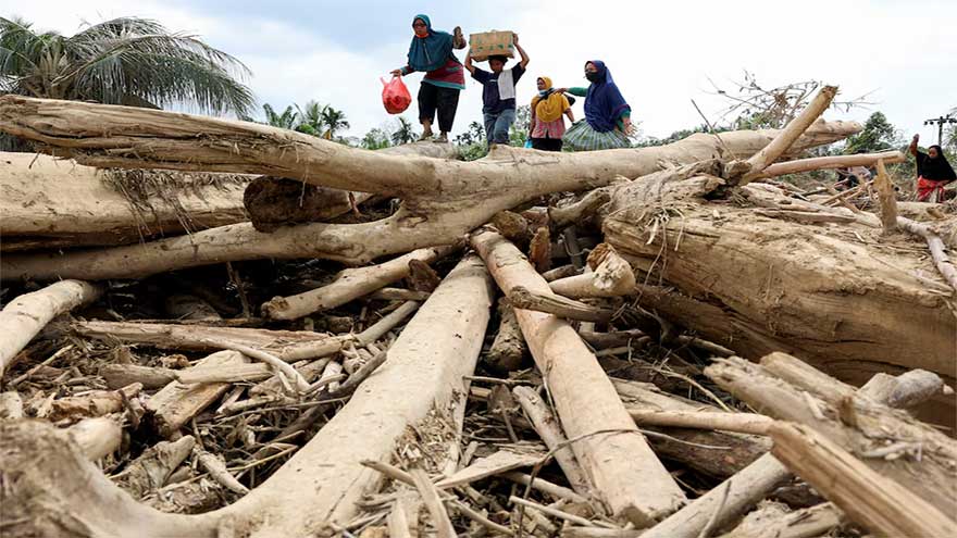 Indonesians climb over logs in walk to aid centre as flood deaths exceed 900