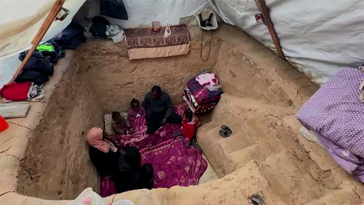 Gazan father digs a pit under tent to protect children from Israeli strikes