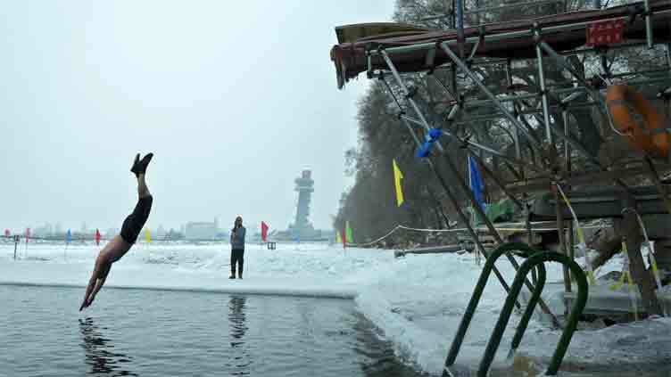 In freezing temperatures, swimmers in China plunge into river