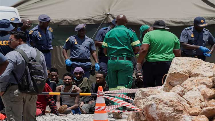 South African police lower cage into mine to check if anyone left after 78 died