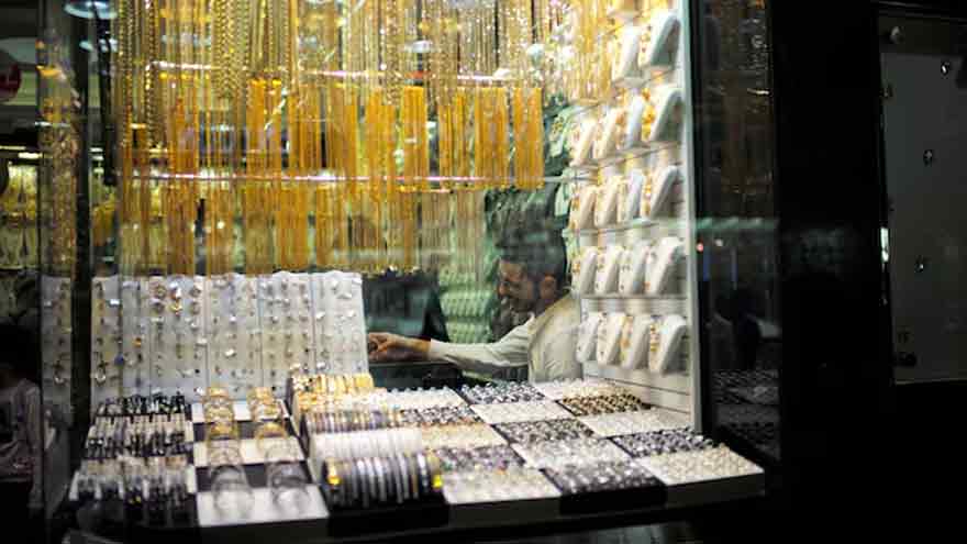 Gold edges higher on softer dollar, trade war intensifies