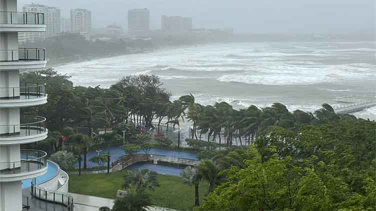 A severe tropical storm heads for southern China after toppling trees on Hainan island