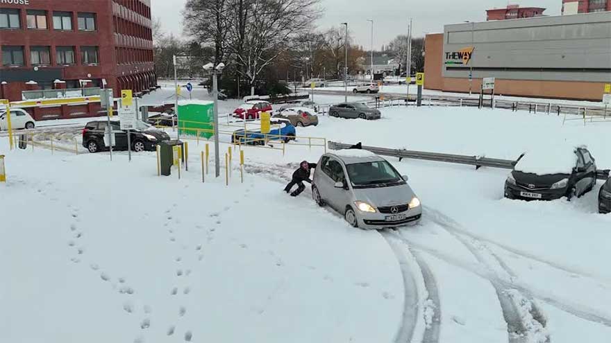Snow sweeps English town, stranding car and slowing commuters